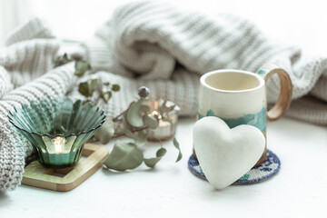 Cozy home composition with cup and decorative heart.