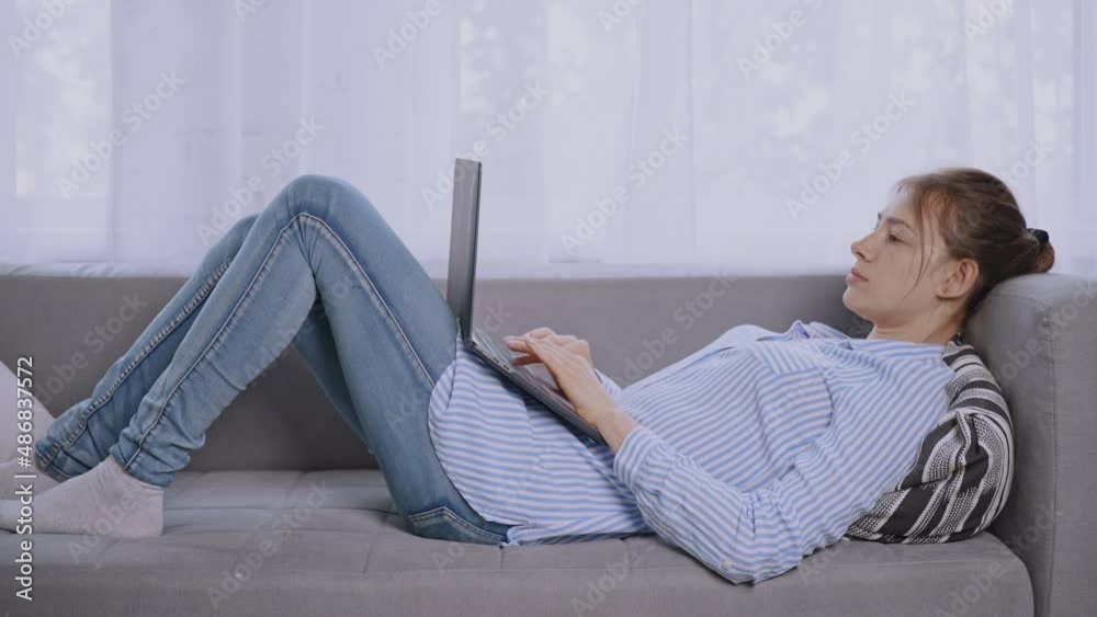Aufkleber student lying on sofa using computer