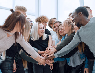 diverse young people putting their hands together