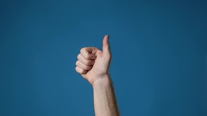 Man's hand show thumbs up at blue background. Male hand shows like sign. 4K, UHD