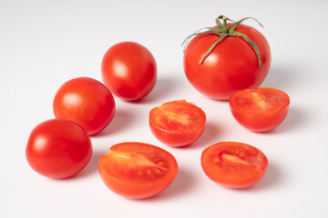 Cut ripe cherry tomato. Big and small tomatoes close up. Red tomatoes isolated on a white background