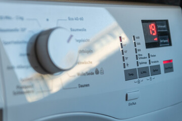Detail view of washing machine control panel with contemporary thermostat and program selection to switch between different programs for laundry cleaning in modern household for housekeepers hygiene