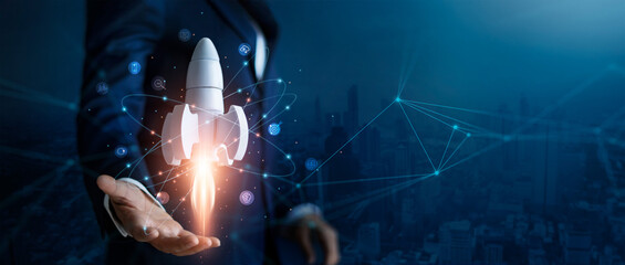 Startup business concept, Businessman control white rocket is launching and soar flying out from...