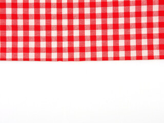 Top view, close-up of red and white checkered fabric or napkin on white table background. Concept kitchen utensils and tableware. Top view, flat lay with copy space..