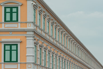 Obraz premium Traditional antique city building in Bangkok, Thailand.orange building with green window frame and blue sky.