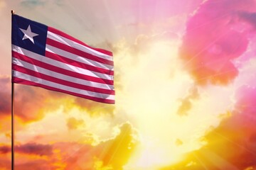 Fluttering Liberia flag in top left corner mockup with the space for your text on beautiful colorful sunset or sunrise background.