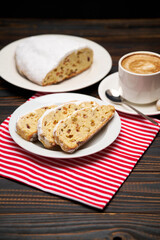 Slices of Traditional Christmas stollen cake with marzipan and dried fruit and cup of coffee