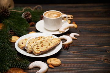 Obraz na płótnie Canvas Sliced Traditional Christmas stollen cake with marzipan and dried fruit with New Year decorations