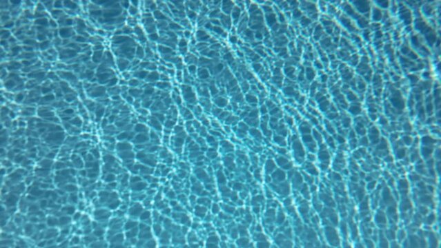 Underwater background, Slow motion glare of sunlight on the bottom. Natural blue background with sunbeams at the bottom 