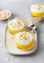 Healthy tropical fruit cream dessert with orange and white layers of mango puree and cream cheese. Vegan food. Clean eating and superfoods concept.