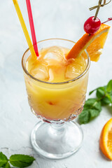 Yellow cocktail with orange mint and ice. Alcoholic or non-alcoholic drink. vertical image. place for text