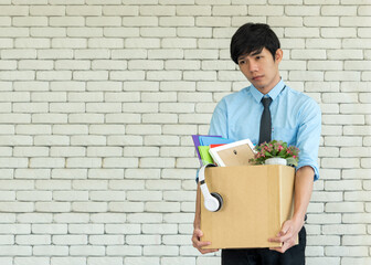 Vertical image, Asian businessman carrying box full of personal belongings after risign or get...