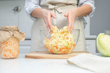 The preparation process fermentation preservation sauerkraut in the kitchen. Light background. Horizontal view. Canned food.