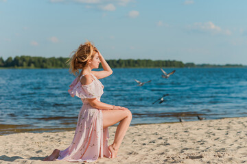 Fototapeta na wymiar Woman in pink romantic soft long dress at beach, sunny warm day. Relax and freedom concept 