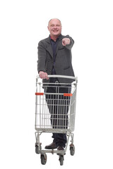 smiling casual man with shopping cart .isolated on a white background.
