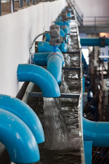 Water purification station. Low depth of field. Blue pipes and flow water. Aeration and filtration. Kyzylorda, Kazakhstan