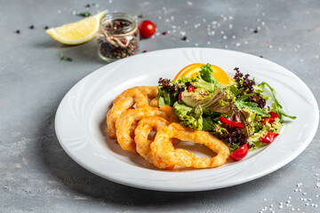 fried crispy onion rings served on round black stone tray, american unhealthy calories meal. Delicious pub style, appetizer, restaurant menu, top view