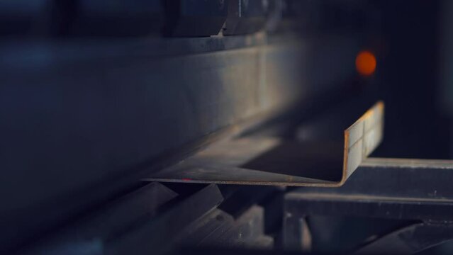 CNC bending machine. Automatic tool, metal sheet bender. Worker put iron sheet on plate of machine