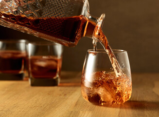 Whiskey is poured into a dammed glass with ice.