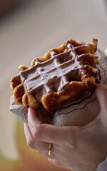 Girl eating a fresh hot waffle with chocolate cream