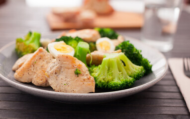 chicken breast with broccoli and quail eggs on plate for healthy dinner