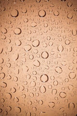 water drops on Brown glass background.