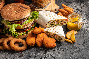 Close-up of home made tasty burger and hot dogs with fried chicken french fries. raditional...