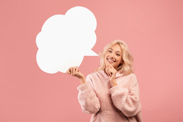 Hey, great idea. Pensive young woman holding blank speech bubble and touching chin, thinking about nice offer