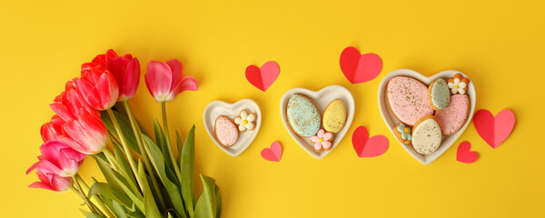 Sweets, pastry, gingerbread cookies for Easter table. Easter eggs heart shaped decor plate, pink...