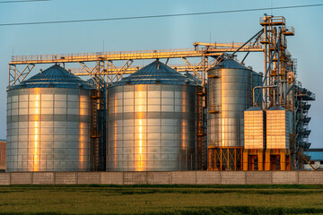 A large modern plant located near a wheat field for the storage and processing of grain crops. view...