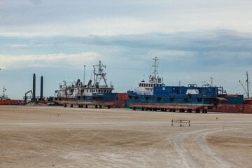 Fototapeta premium Mangystau, Kazakhstan - May 19, 2012: Ships on Caspian Sea ship-repairing shore base. Bautino bay.