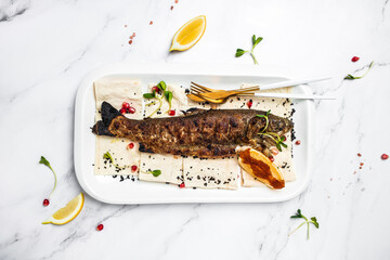 Baked trout fish with salt, lemon. Grilled trout. Fish dish fried fish fillet with vegetables. Ketogenic, keto or paleo diet lunch, Healthy food trend. Top view
