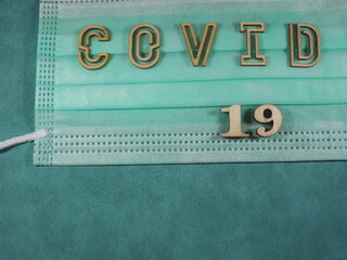 The word covid variant omicron in wooden letters on the face mask. High quality photo