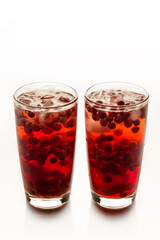 Cranberry juice with ice on a white background.
