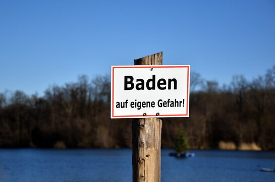 "Baden auf eigene Gefahr"-Schild an einem See
