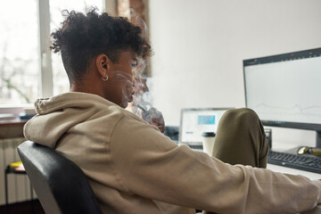 Focused exhausted trader working at home office and vaping