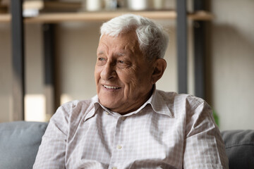 Positive pensive older 80s man looking away with good thoughts, thinking with happy smile, dreaming of optimistic future. Head shot portrait in casual. Elderly age, retirement concept