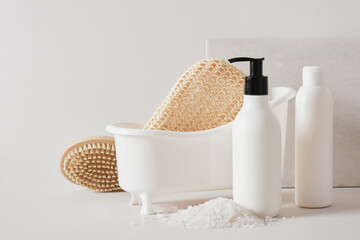 a washcloth for a shower in a miniature white plastic bathtub and a mock-up blank bottle
