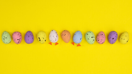 Creative Easter colorful layout with eggs on vibrant yellow background. Flat lay spring concept.