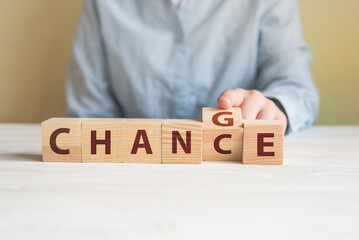 Hand flip wooden cube with word change to chance,
