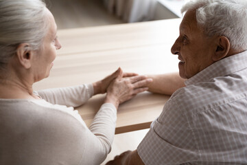 Caring elderly grey haired wife giving comfort, empathy to old smiling husband. Senior married...