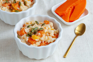 Rice porridge with pumpkin and pumpkin seeds on white table