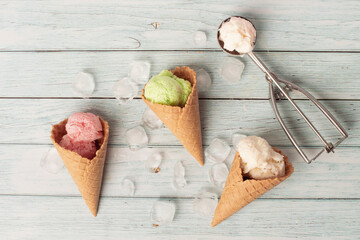 ice cream cones on a bright blue wooden table. Summer, bright sun. Top view, copy space