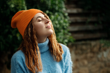 Sensitivity to nature concept.Allow your mind and body to unwind.Portrait carefree beautiful happy woman traveler,girl wearing cozy sweater and knitted orange hat, clothing autumn season.