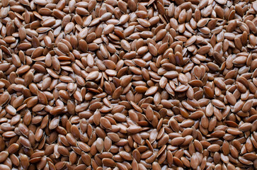 Background of flax seeds, close-up, top view. Flaxseed, background, top view. Dry flax seeds, background. Linum usitatissimum is the name of the brown flax seed. Flaxseed, background, top view.