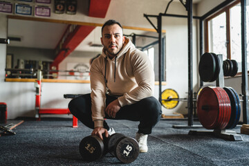 one man front view of young male athlete with dumbbells at the gym front view real people copy space