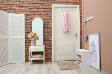 Hallway interior with mirror and white furniture. Stylish accessories