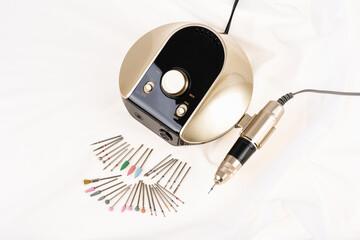Professional electric nail drill manicure and pedicure machine and set of diamond cutters on white...