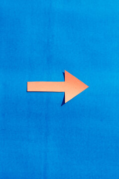 A Right Facing Arrow Indicating Right Direction. Isolated On Blue Background. Useful For Signage And For Way Finding And Surface Markings.