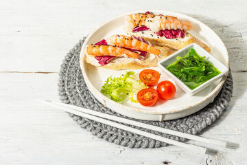 Open sandwiches with boiled shrimps, cream cheese, salad leaves, and Chuka salad. Seafood